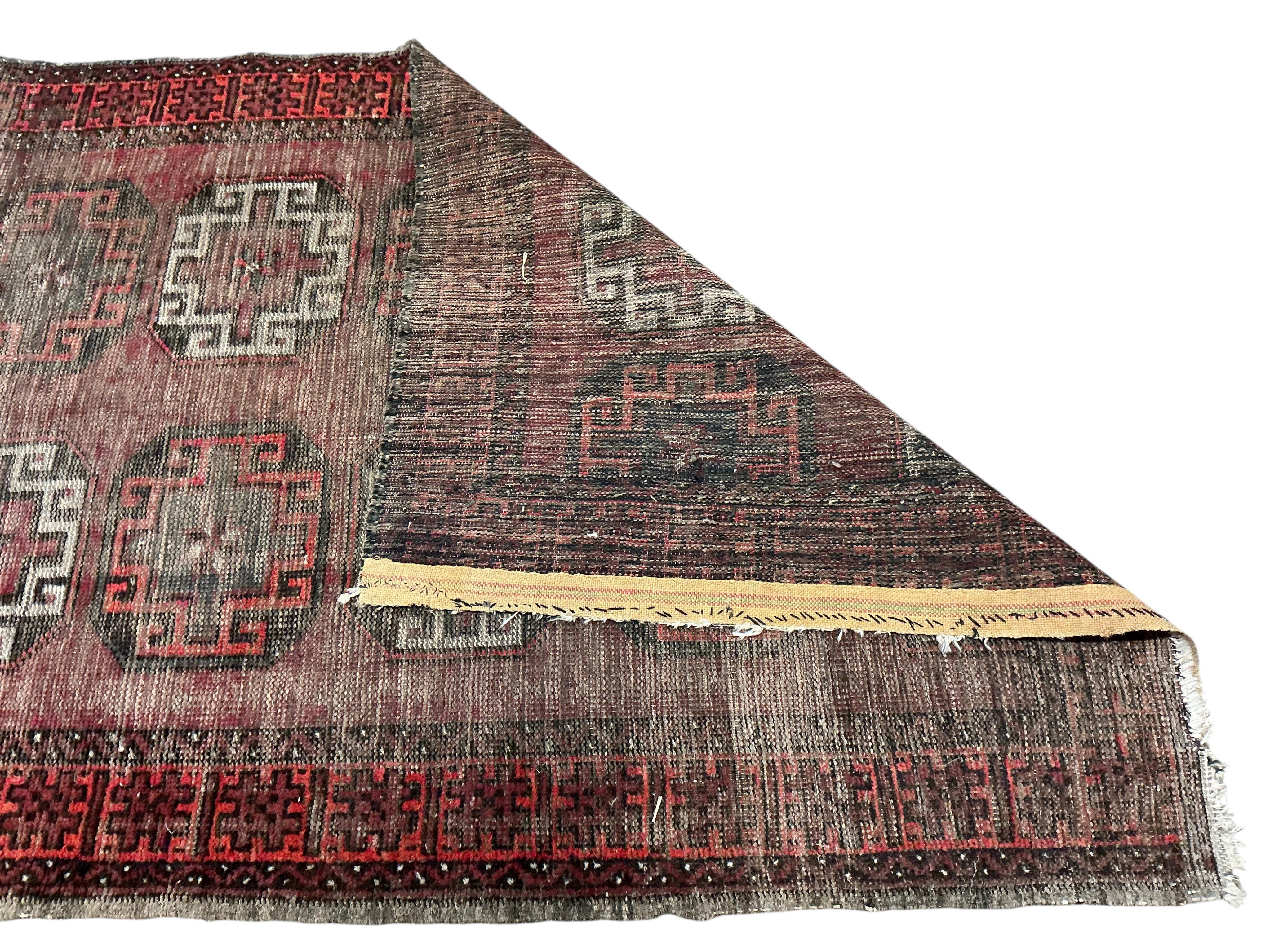 An Afghan red ground runner, 300 x 82cm and a rug, (worn)